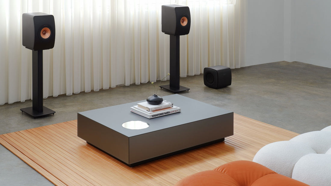 Modern living room with a KEF LS50 Wireless II mounted to a S2 floor stand next to black KC62 subwoofer 