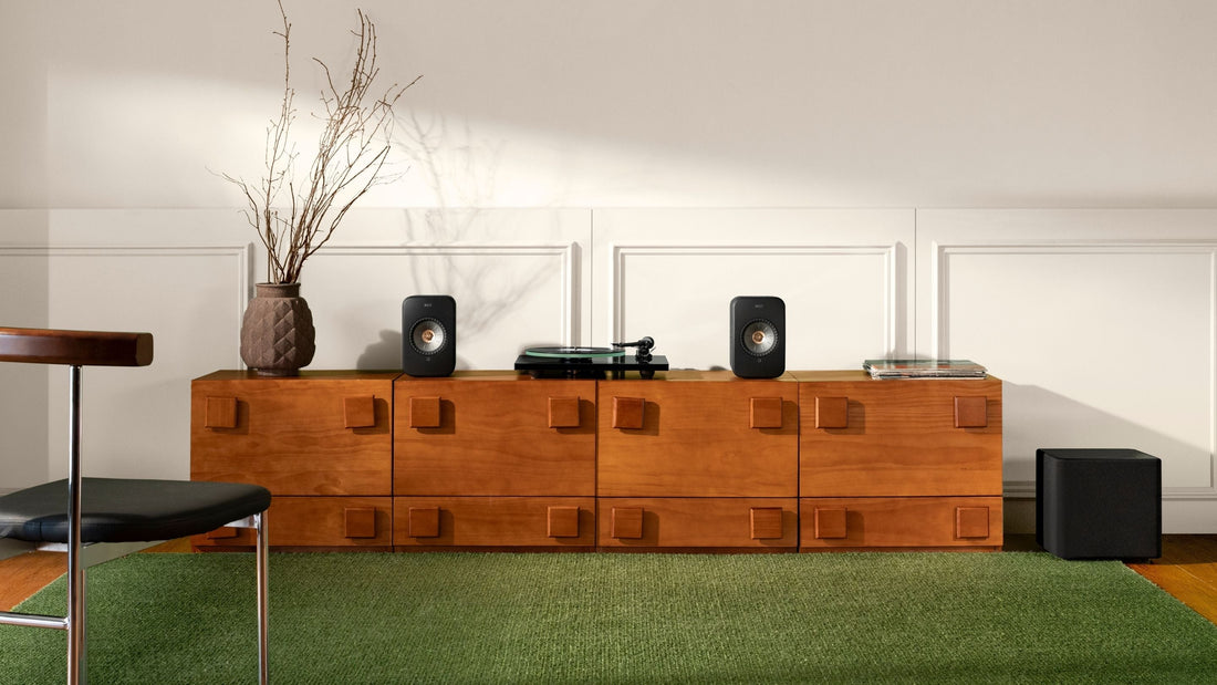 Wooden entertainment console with speakers and decor in a room with green carpet.