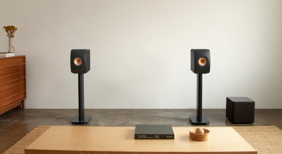 KEF Regallautsprecher auf Ständern mit kompaktem schwarzem Subwoofer in einem minimalistischen modernen Wohnzimmer