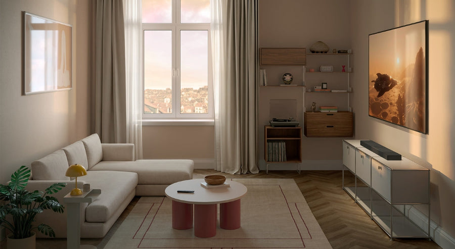 Modernes Wohnzimmer mit wandmontiertem Fernseher, beiger Eckcouch, sanfter natürlicher Beleuchtung und minimalistischer Einrichtung in neutralen Farbtönen.